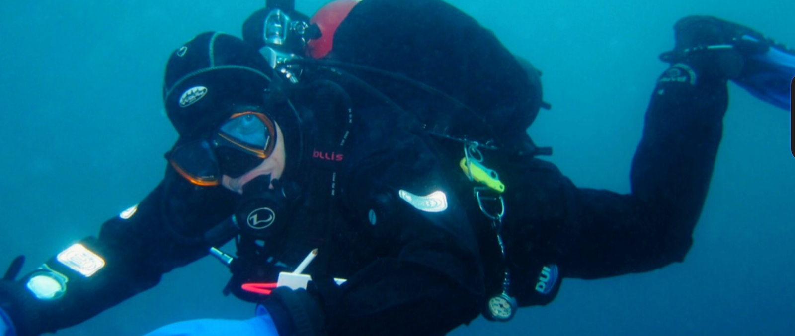Scuba diver in a drysuit hovering horizontally with a backplate and wing BCD