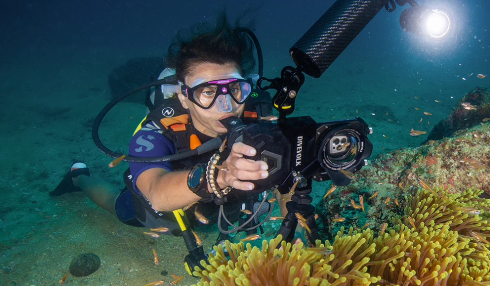Scuba diver using a Divevolk underwater camera housing to photograph marine life on the reef
